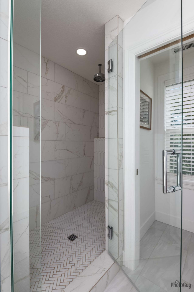 This is an example of a mid-sized contemporary master bathroom in Other with shaker cabinets, medium wood cabinets, a freestanding tub, an alcove shower, a one-piece toilet, white tile, white walls, porcelain floors, an undermount sink, grey floor, a hinged shower door, white benchtops, a double vanity, a built-in vanity, ceramic tile and solid surface benchtops.
