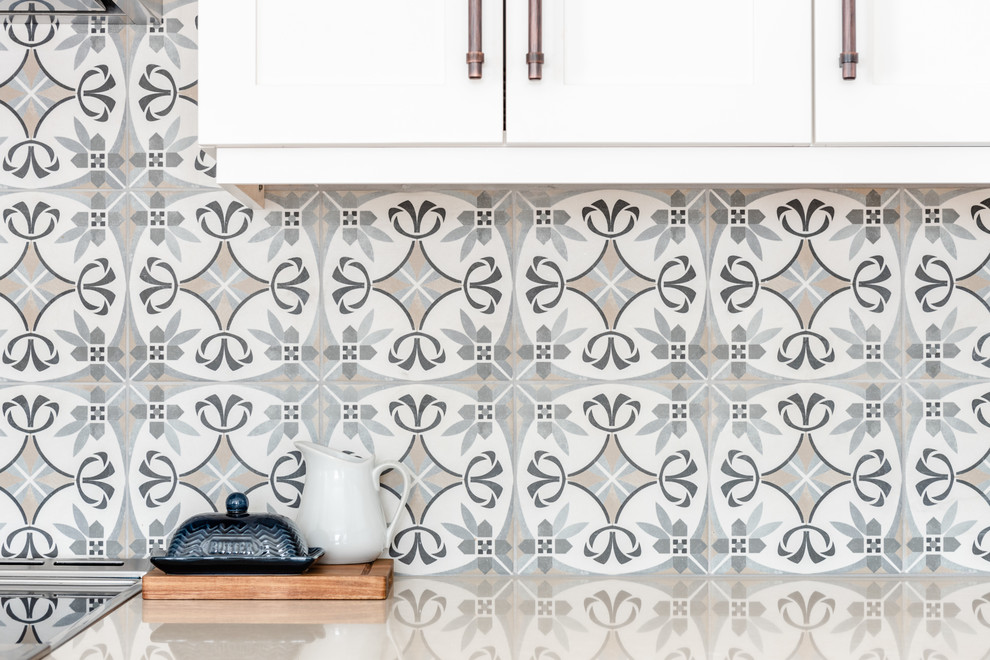 Kitchen pantry - mid-sized transitional l-shaped medium tone wood floor and brown floor kitchen pantry idea with an undermount sink, shaker cabinets, white cabinets, quartzite countertops, gray backsplash, porcelain backsplash, stainless steel appliances, an island and white countertops