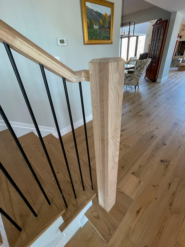 На фото: огромная прямая деревянная лестница в стиле неоклассика (современная классика) с деревянными ступенями и перилами из смешанных материалов
