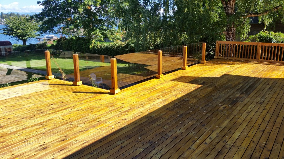 Design ideas for a large traditional backyard deck in Seattle with a roof extension.