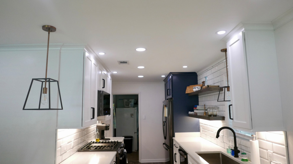 Inspiration for a mid-sized transitional galley porcelain tile and gray floor eat-in kitchen remodel with an undermount sink, shaker cabinets, white cabinets, quartz countertops, white backsplash, subway tile backsplash, black appliances, no island and white countertops