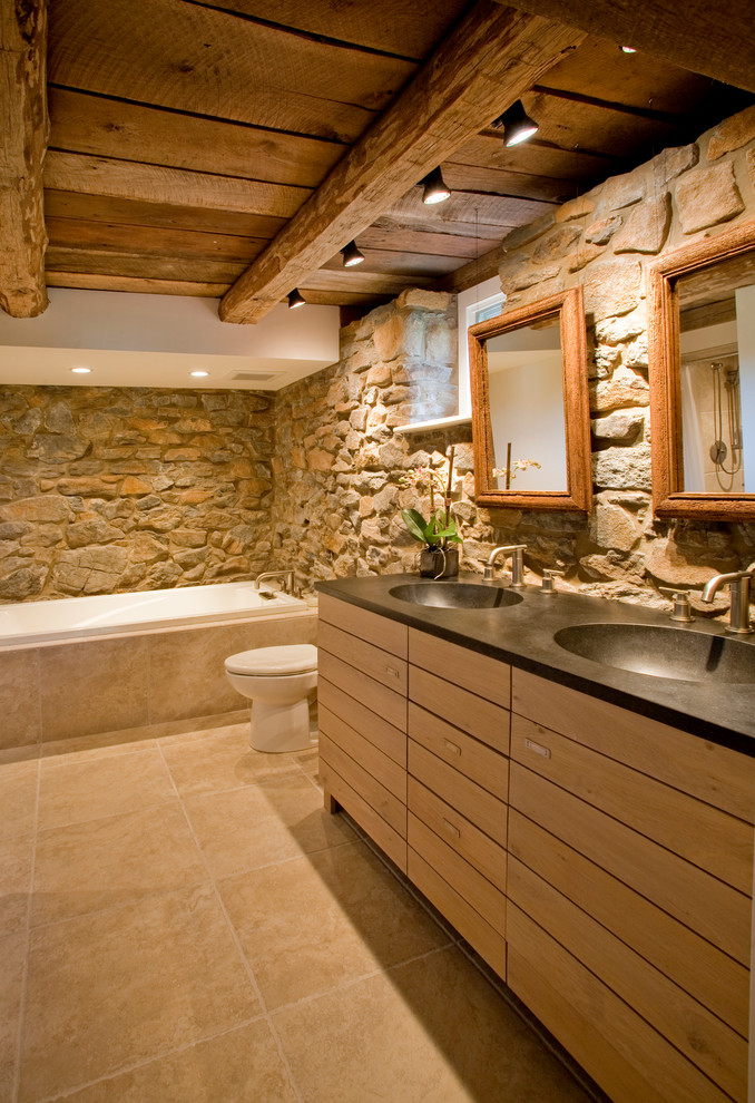 This is an example of a large country master bathroom in Philadelphia with an undermount sink, granite benchtops, a drop-in tub, a two-piece toilet, beige tile, ceramic tile and ceramic floors.