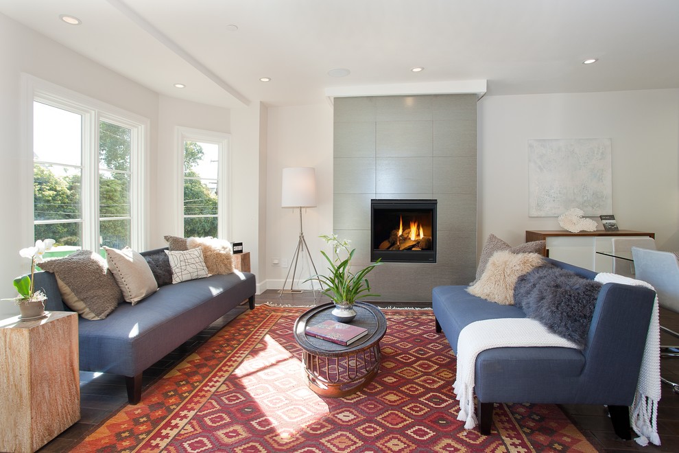 Photo of a transitional living room in San Francisco with white walls, dark hardwood floors, a standard fireplace and a tile fireplace surround.