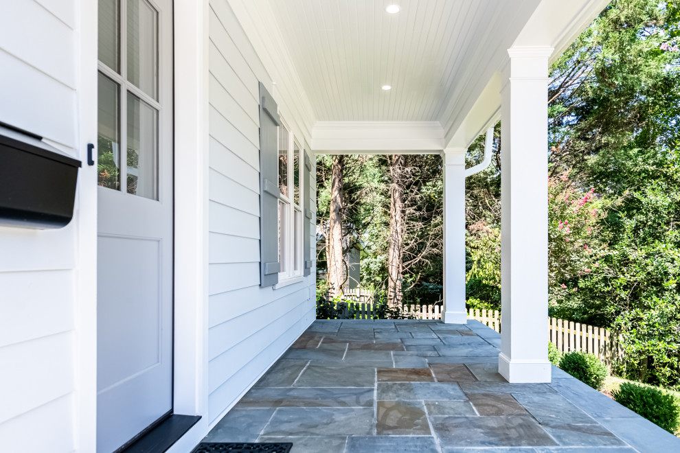Cette photo montre un porche d'entrée de maison avant nature avec des colonnes et une extension de toiture.