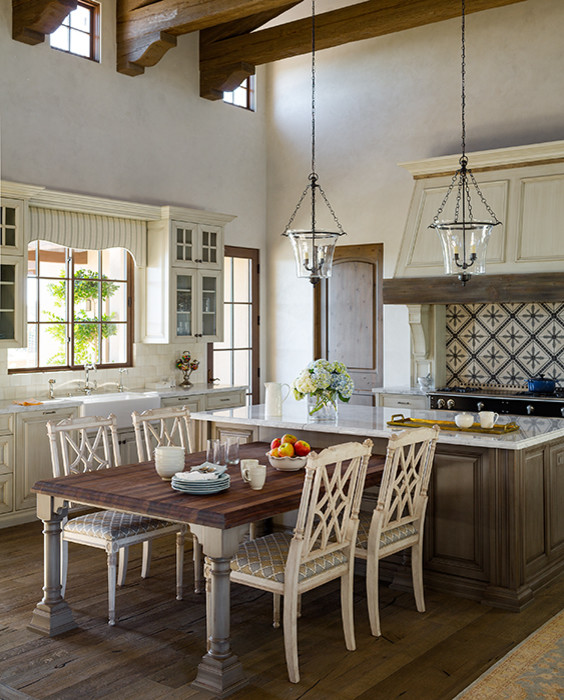 This is an example of a transitional eat-in kitchen in Phoenix with a farmhouse sink, glass-front cabinets, beige cabinets, marble benchtops, multi-coloured splashback, cement tile splashback, panelled appliances, medium hardwood floors and with island.