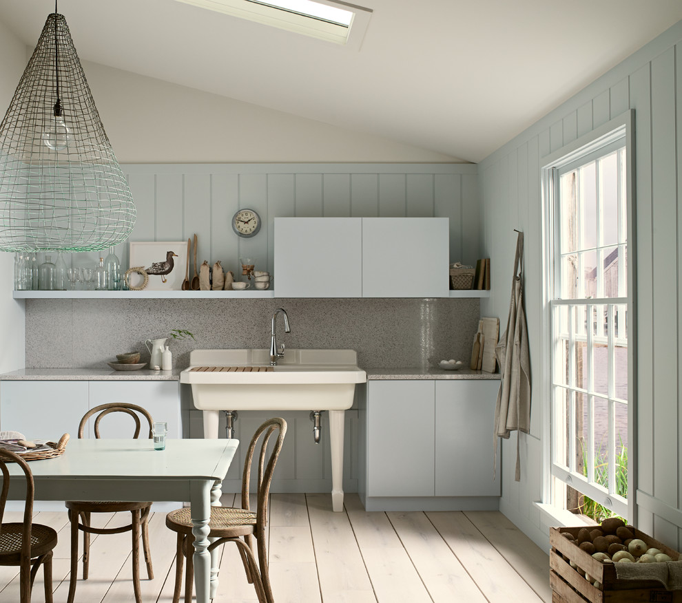 Foto de cocina campestre con fregadero sobremueble, armarios con paneles lisos, puertas de armario azules, salpicadero verde y suelo de madera pintada