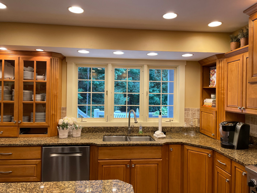 Inspiration for a transitional medium tone wood floor kitchen remodel in Indianapolis with an undermount sink, medium tone wood cabinets, quartzite countertops, white backsplash, ceramic backsplash, an island and beige countertops