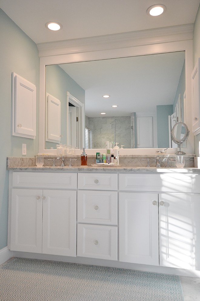 Design ideas for a large transitional master bathroom in Philadelphia with raised-panel cabinets, white cabinets, a freestanding tub, a corner shower, a one-piece toilet, white tile, stone slab, blue walls, marble floors, marble benchtops and an undermount sink.