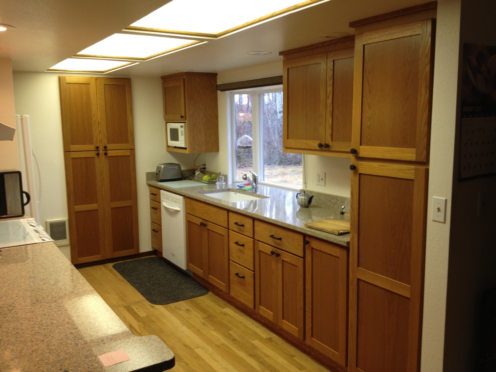 Mid-sized modern single-wall separate kitchen in Seattle with an undermount sink, shaker cabinets, medium wood cabinets, granite benchtops, white appliances, light hardwood floors and with island.