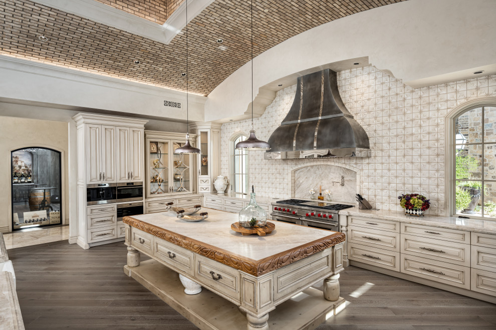Inspiration for a l-shaped kitchen in Phoenix with raised-panel cabinets, beige cabinets, beige splashback, stainless steel appliances, dark hardwood floors, with island, brown floor, beige benchtop and vaulted.