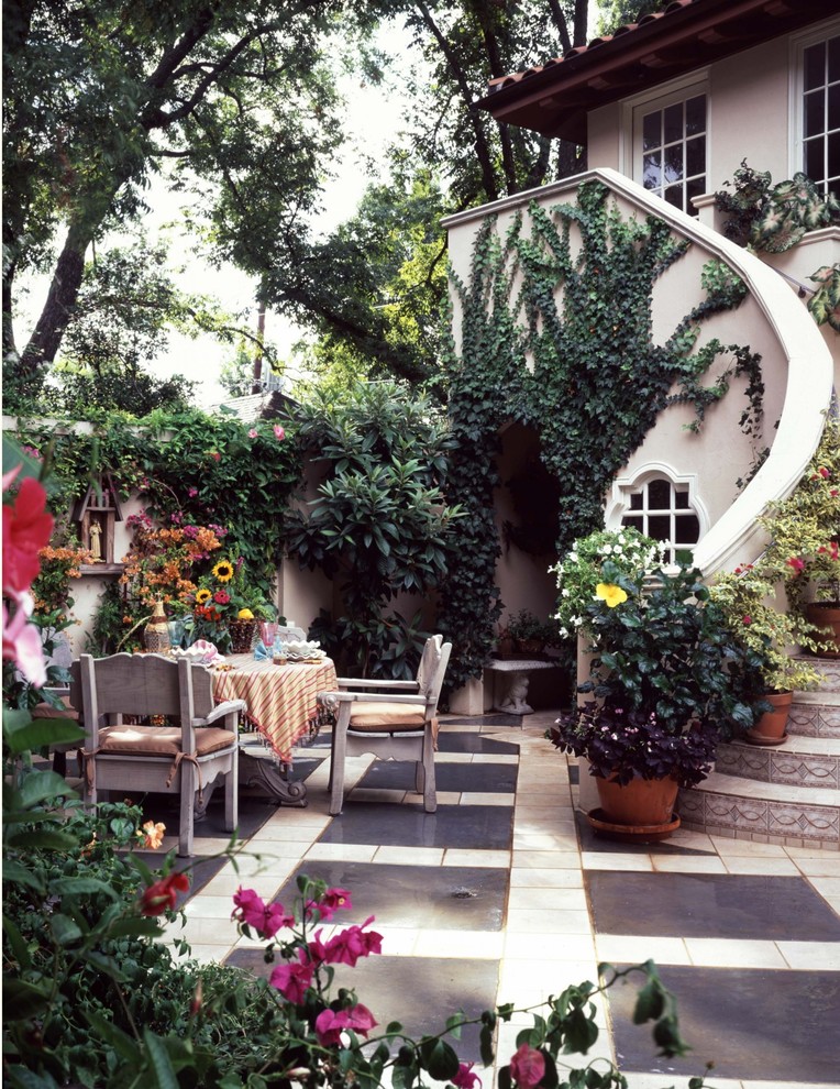 This is an example of a mid-sized mediterranean backyard patio in Dallas with a container garden, tile and no cover.