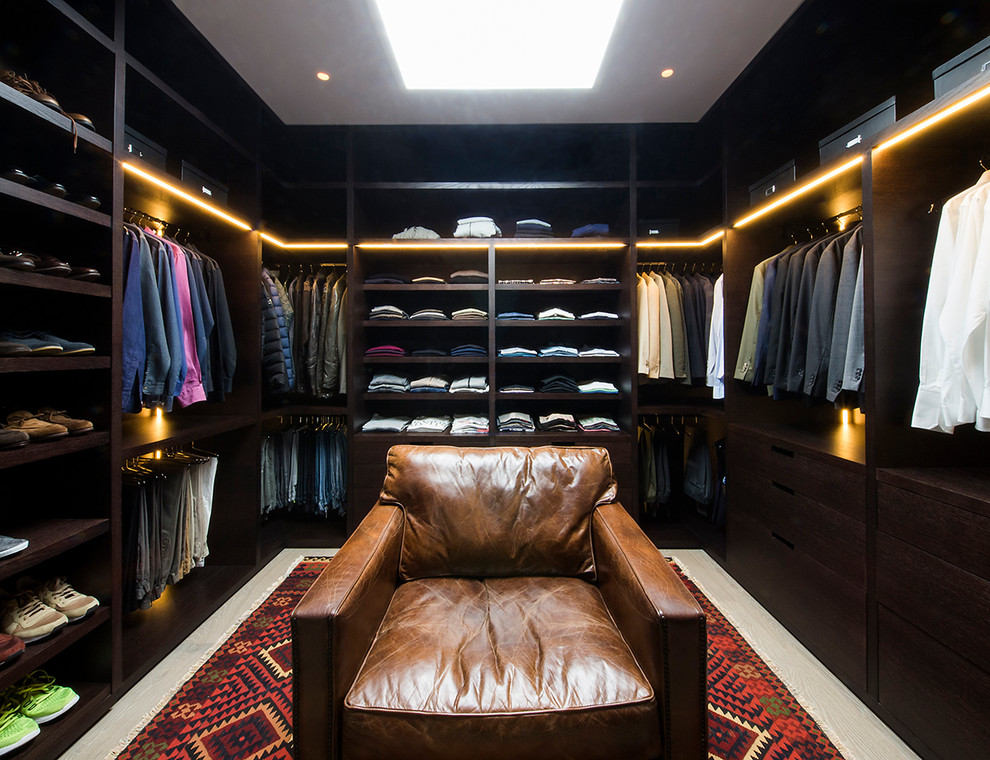 Photo of a large contemporary gender-neutral walk-in wardrobe in Madrid with open cabinets, dark wood cabinets and carpet.