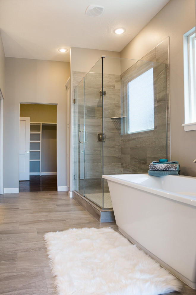 Freestanding bathtub - large transitional master gray tile and porcelain tile porcelain tile and gray floor freestanding bathtub idea with flat-panel cabinets, white cabinets, gray walls, an integrated sink and solid surface countertops