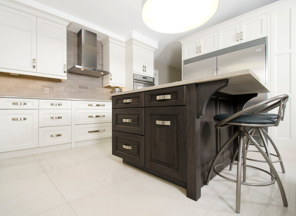 Transitional u-shaped limestone floor eat-in kitchen photo with an undermount sink, raised-panel cabinets, gray cabinets, quartz countertops, beige backsplash, stone tile backsplash, stainless steel appliances and an island