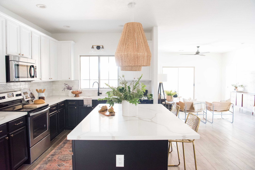 Example of a mid-sized transitional l-shaped open concept kitchen design in Phoenix with white backsplash, ceramic backsplash, stainless steel appliances and an island