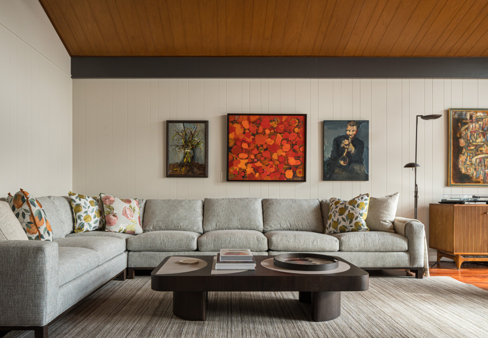 Cette image montre un salon vintage avec un sol en bois brun, un plafond en bois et du lambris.