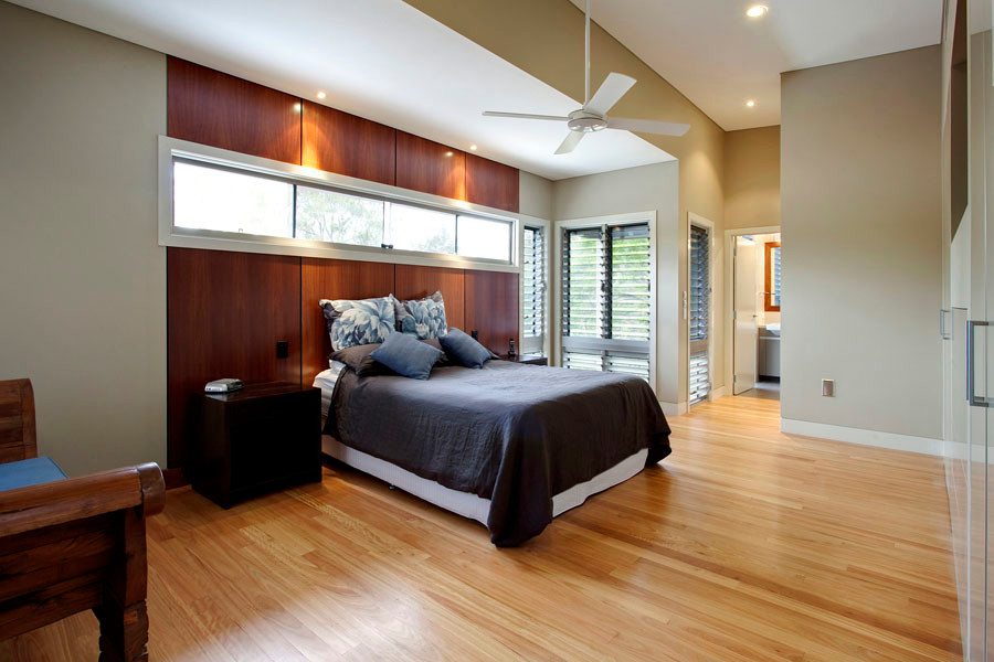 Photo of an expansive contemporary master bedroom in Brisbane with beige walls, light hardwood floors, no fireplace and brown floor.