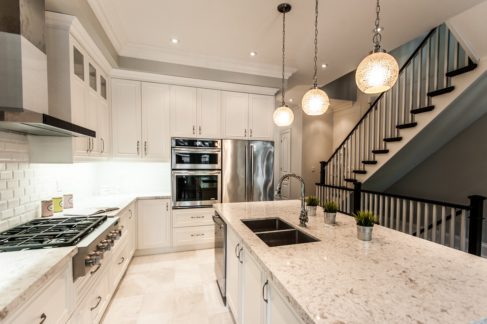 Mid-sized transitional l-shaped open plan kitchen in Toronto with recessed-panel cabinets, white cabinets, granite benchtops, white splashback, stainless steel appliances, with island, marble floors, a double-bowl sink and ceramic splashback.