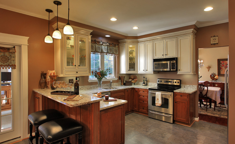 This is an example of a mid-sized traditional u-shaped eat-in kitchen in Baltimore with a single-bowl sink, shaker cabinets, medium wood cabinets, granite benchtops, stainless steel appliances, linoleum floors, a peninsula and beige floor.