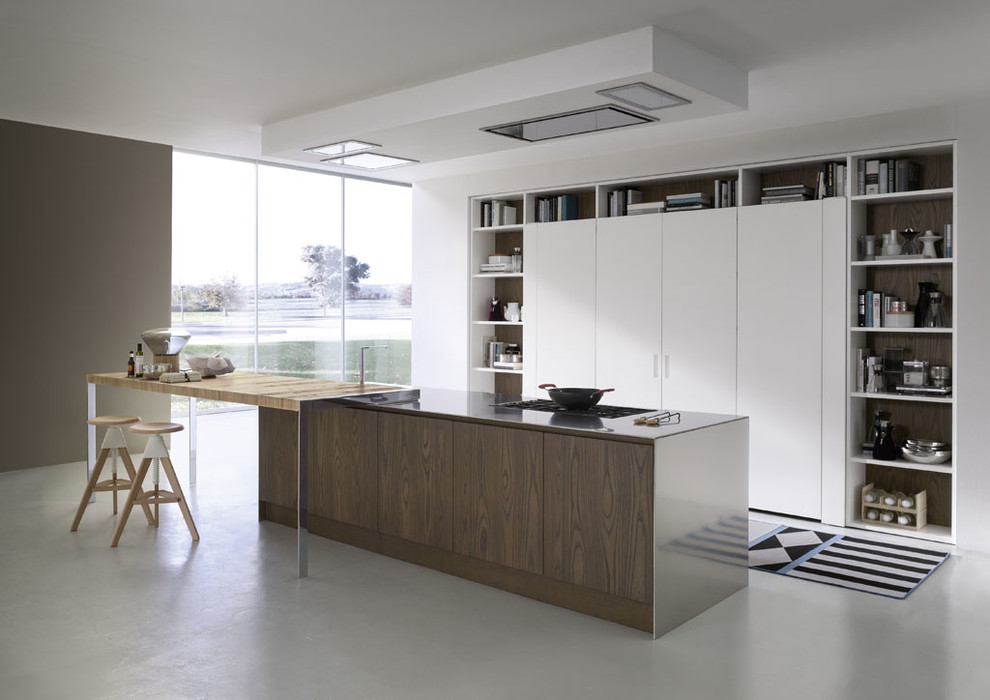 This is an example of a contemporary galley eat-in kitchen in New York with flat-panel cabinets, light wood cabinets, stainless steel appliances and with island.