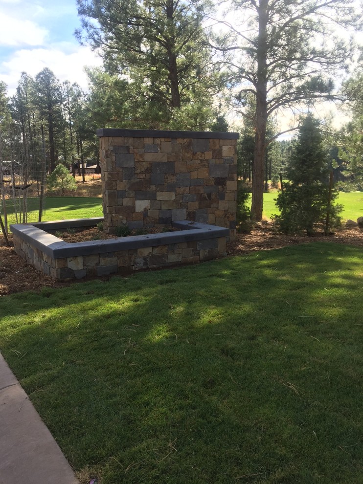 Design ideas for a large rustic backyard retaining wall landscape in Phoenix.