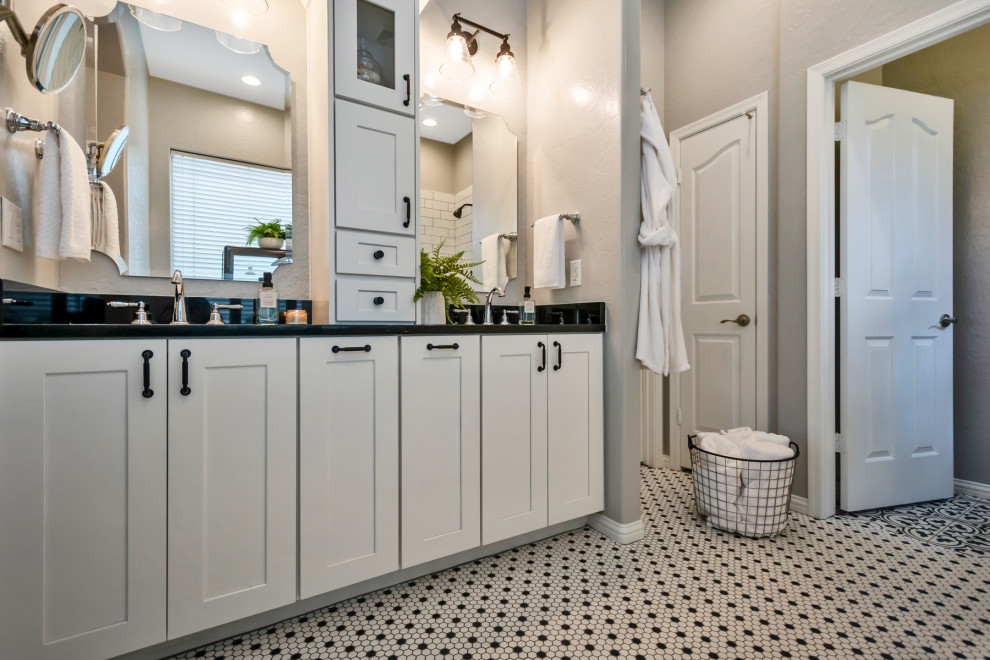 Photo of a mid-sized transitional master bathroom in Phoenix with shaker cabinets, white cabinets, a corner shower, white tile, subway tile, grey walls, mosaic tile floors, an undermount sink, granite benchtops, white floor, a hinged shower door and black benchtops.