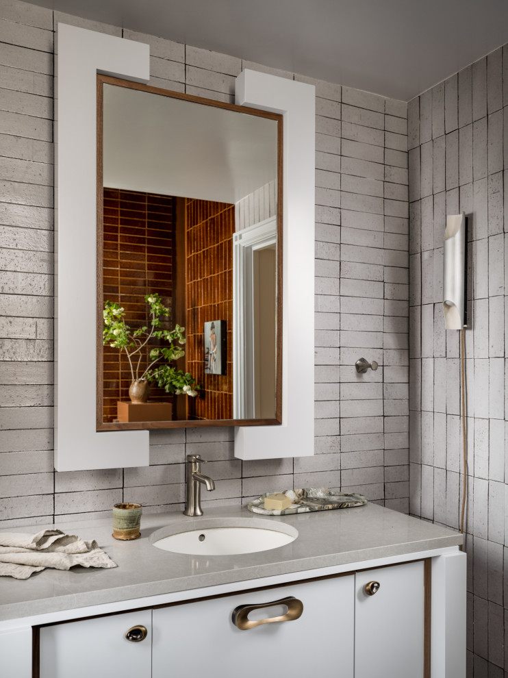 This is an example of a mid-sized scandinavian master bathroom in New York with a claw-foot tub, white tile, ceramic tile, brick floors, multi-coloured floor and a single vanity.