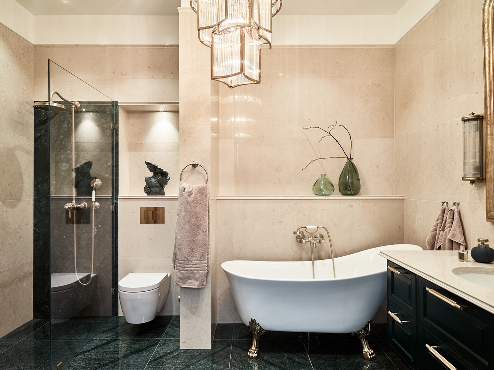 Inspiration for a large traditional master bathroom in Gothenburg with a wall-mount toilet, beige tile, beige walls, raised-panel cabinets, black cabinets, a claw-foot tub, a corner shower, an undermount sink, green floor and beige benchtops.