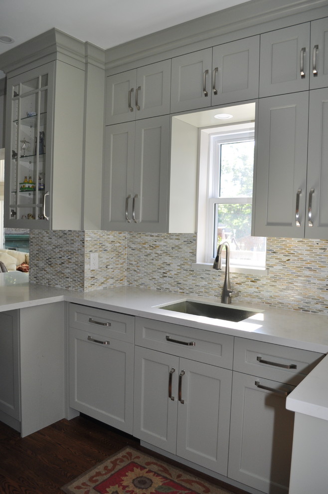 Inspiration for a mid-sized transitional galley medium tone wood floor and brown floor eat-in kitchen remodel in Toronto with an undermount sink, shaker cabinets, green cabinets, quartz countertops, green backsplash, mosaic tile backsplash, stainless steel appliances and a peninsula
