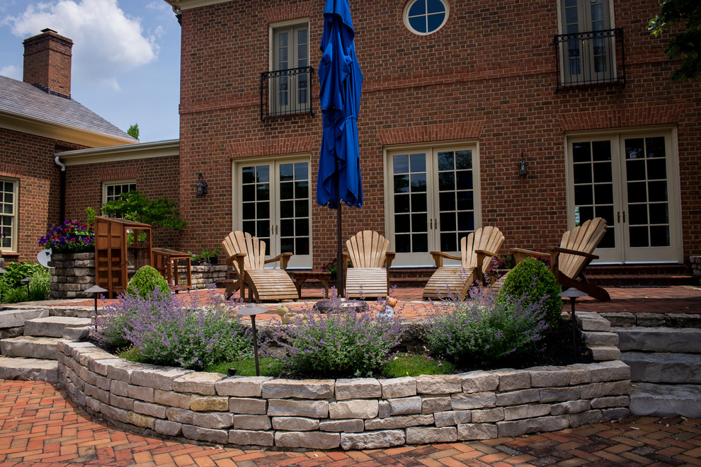 Design ideas for a large traditional backyard patio in Columbus with brick pavers and no cover.