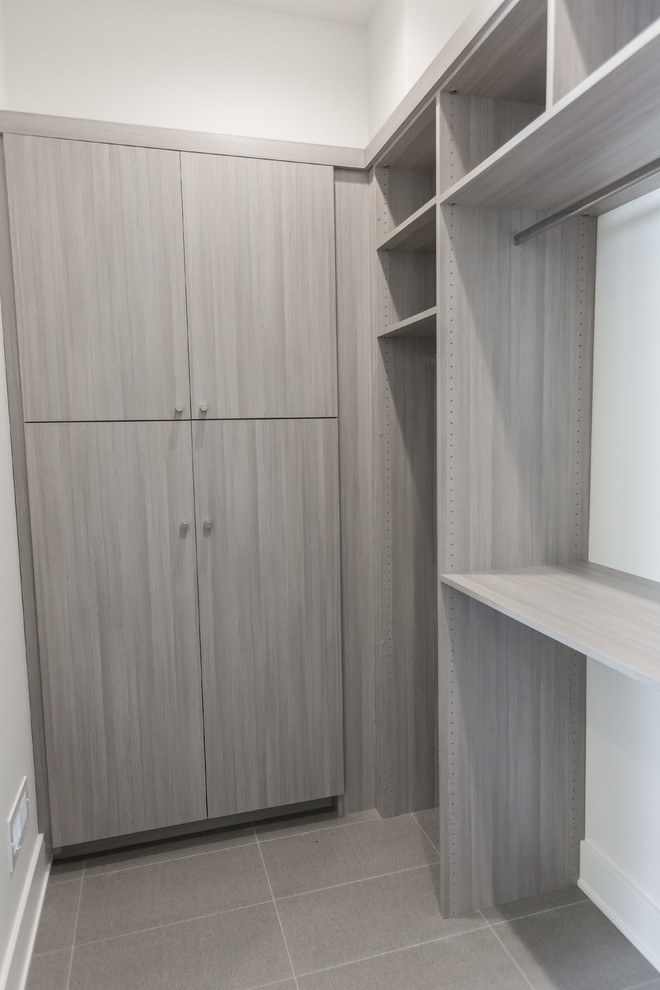 This is an example of a large gender-neutral dressing room in Minneapolis with flat-panel cabinets, grey cabinets, ceramic floors and grey floor.