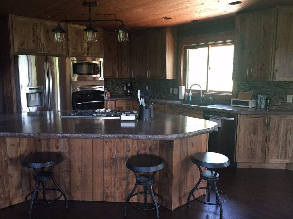 Example of a mid-sized mountain style l-shaped open concept kitchen design with an undermount sink, shaker cabinets, medium tone wood cabinets, concrete countertops, beige backsplash, mosaic tile backsplash, stainless steel appliances and an island