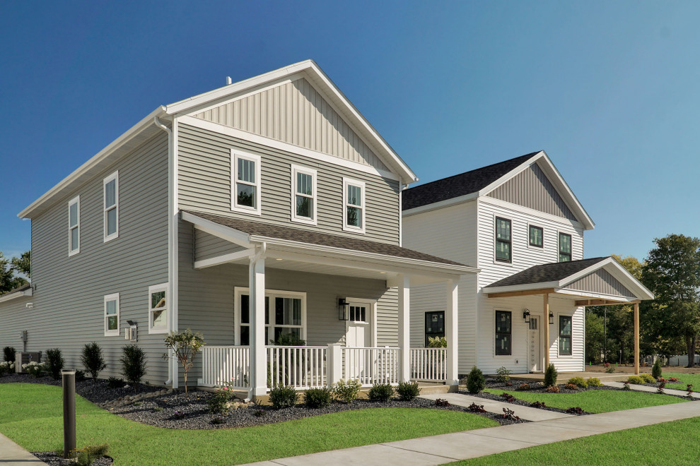 Cette image montre une façade de maison multicolore rustique en planches et couvre-joints de taille moyenne et à un étage avec un revêtement en vinyle, un toit à deux pans, un toit en shingle et un toit noir.