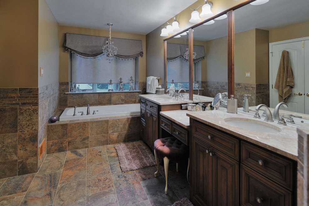 Photo of a large traditional master bathroom in Philadelphia with an undermount sink, raised-panel cabinets, dark wood cabinets, marble benchtops, a drop-in tub, a corner shower, a two-piece toilet, brown tile, porcelain tile, brown walls and porcelain floors.