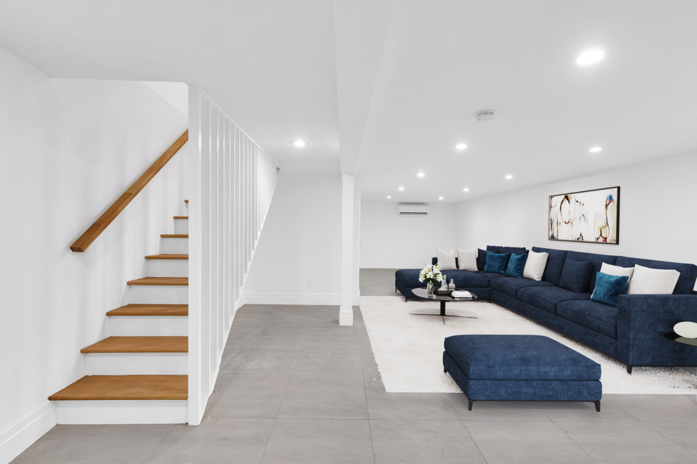 Photo of a large modern basement in New York with porcelain flooring and grey floors.