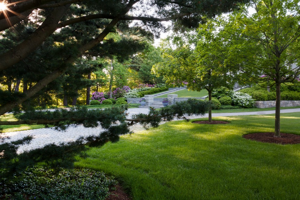 This is an example of an expansive traditional front yard garden for summer in Boston with natural stone pavers.