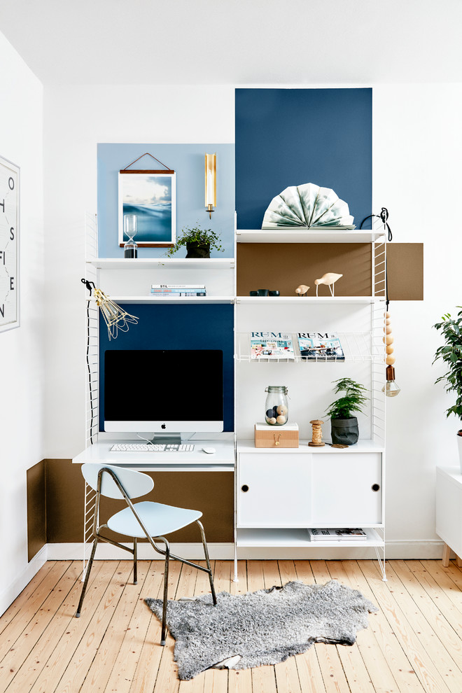 Inspiration for a mid-sized scandinavian study room in Other with multi-coloured walls, light hardwood floors, a freestanding desk and no fireplace.