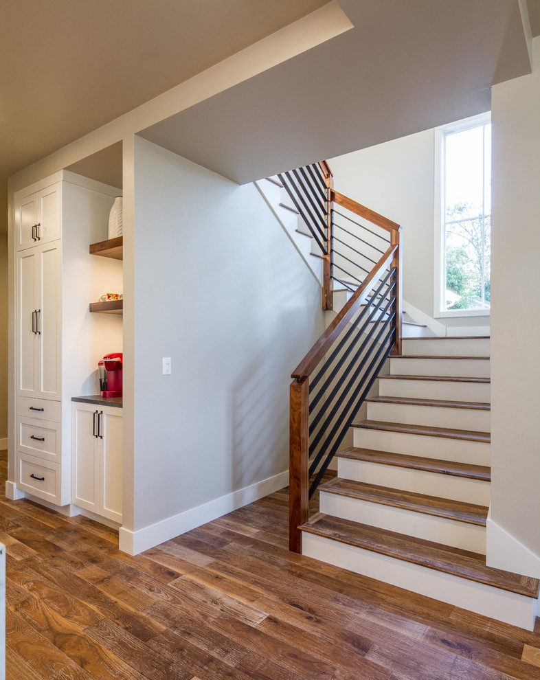 Mid-sized country wood u-shaped staircase in Other with painted wood risers and metal railing.