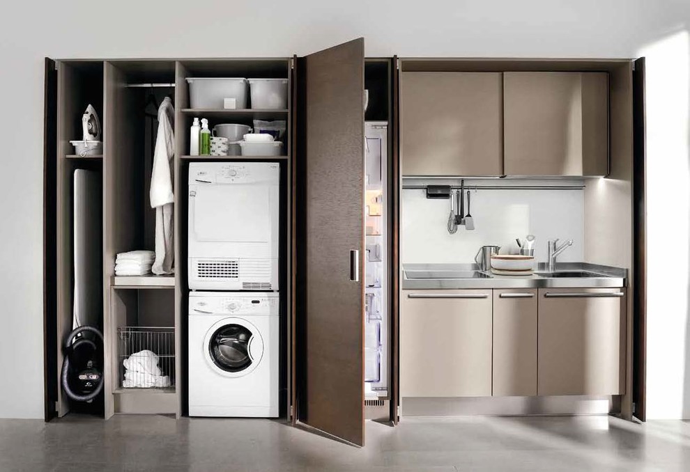 Small modern single-wall utility room in New York with a drop-in sink, flat-panel cabinets, stainless steel benchtops, white walls, concrete floors, a stacked washer and dryer, grey floor and brown cabinets.