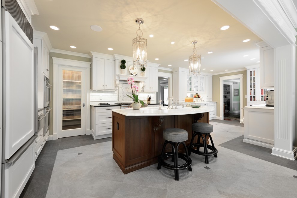 Large traditional u-shaped kitchen in Louisville with white cabinets, recessed-panel cabinets, white splashback, panelled appliances, an undermount sink, quartz benchtops, with island, grey floor and white benchtop.