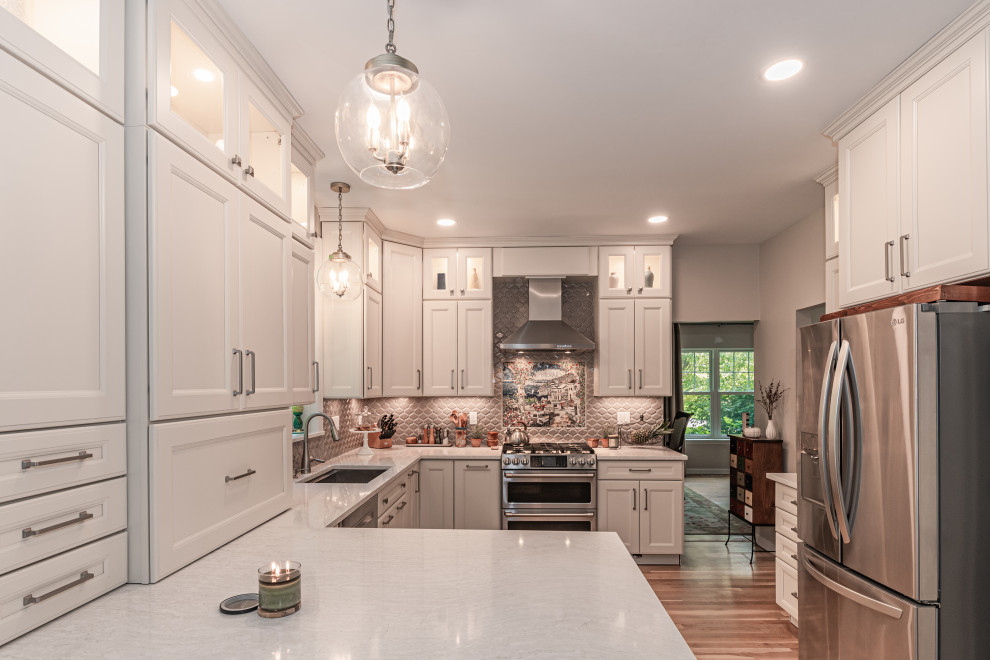 Inspiration for a mid-sized modern medium tone wood floor and gray floor eat-in kitchen remodel in Other with an undermount sink, raised-panel cabinets, white cabinets, quartzite countertops, beige backsplash, ceramic backsplash, stainless steel appliances, no island and white countertops