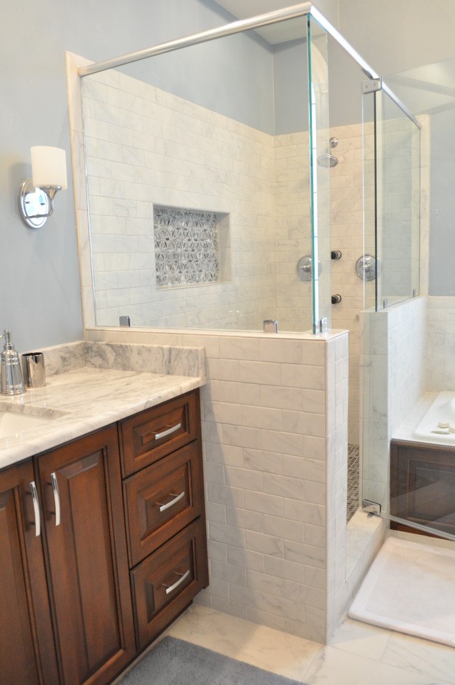 Design ideas for a large traditional master bathroom in Atlanta with raised-panel cabinets, dark wood cabinets, a drop-in tub, a corner shower, an undermount sink, marble benchtops, a two-piece toilet, gray tile, blue walls and marble floors.