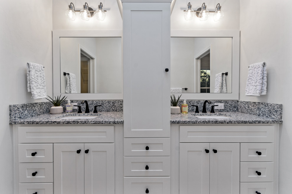 Mid-sized country white tile and subway tile cement tile floor, brown floor and double-sink bathroom photo in Other with shaker cabinets, white cabinets, a two-piece toilet, gray walls, an undermount sink, granite countertops, multicolored countertops, a niche and a built-in vanity