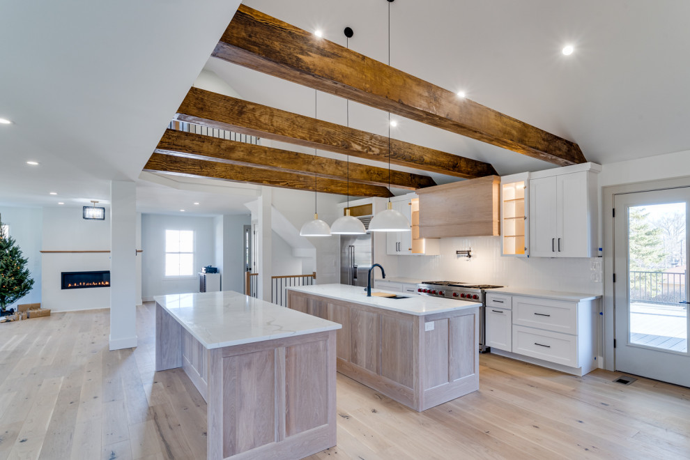 Large transitional exposed beam kitchen photo in Cincinnati with flat-panel cabinets, white cabinets, marble countertops, white backsplash, subway tile backsplash, stainless steel appliances, two islands and white countertops