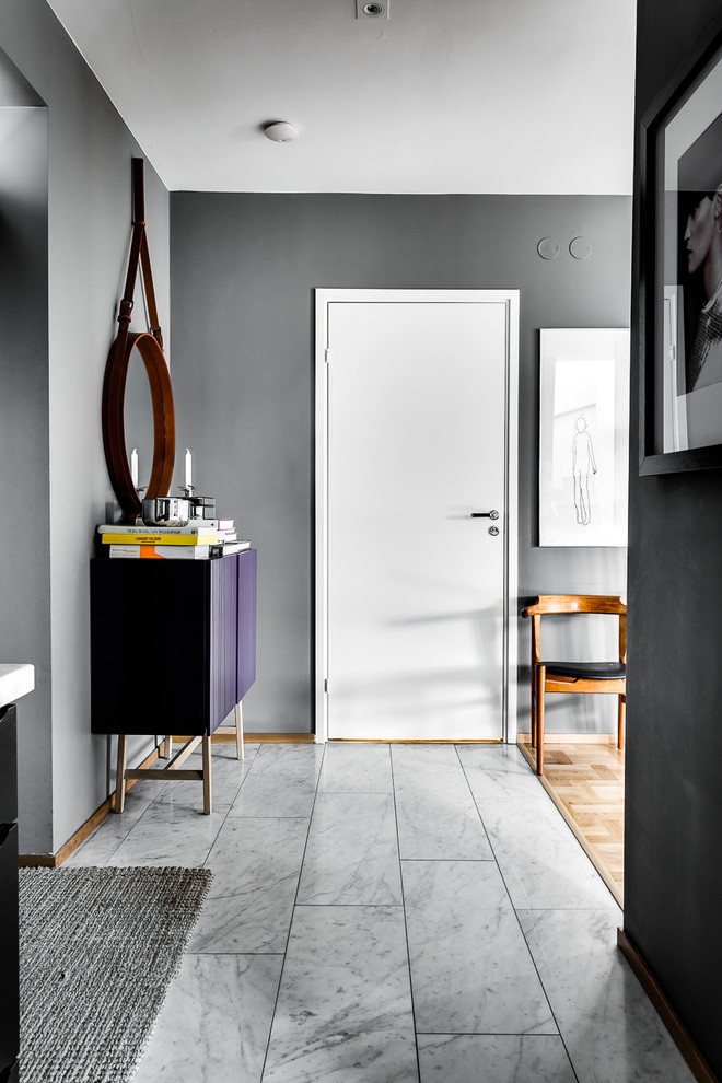 This is an example of a mid-sized scandinavian entryway in Stockholm with white walls and light hardwood floors.