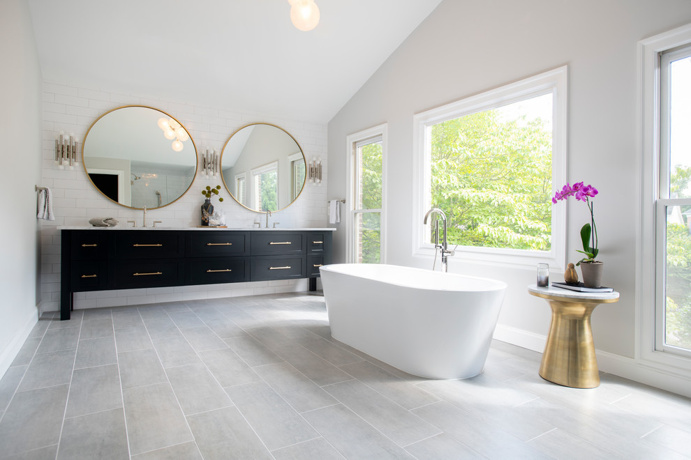 Design ideas for a transitional master bathroom in DC Metro with recessed-panel cabinets, black cabinets, a freestanding tub, white tile, subway tile, grey walls, an undermount sink, grey floor and white benchtops.