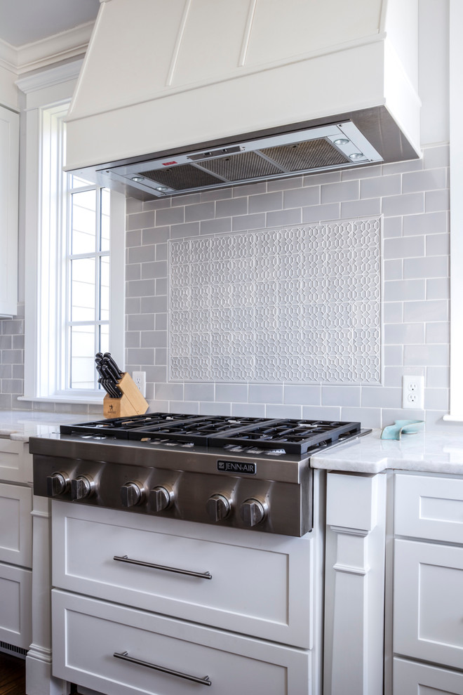 Mid-sized transitional kitchen photo with shaker cabinets, white cabinets, quartzite countertops, gray backsplash, ceramic backsplash, stainless steel appliances and white countertops