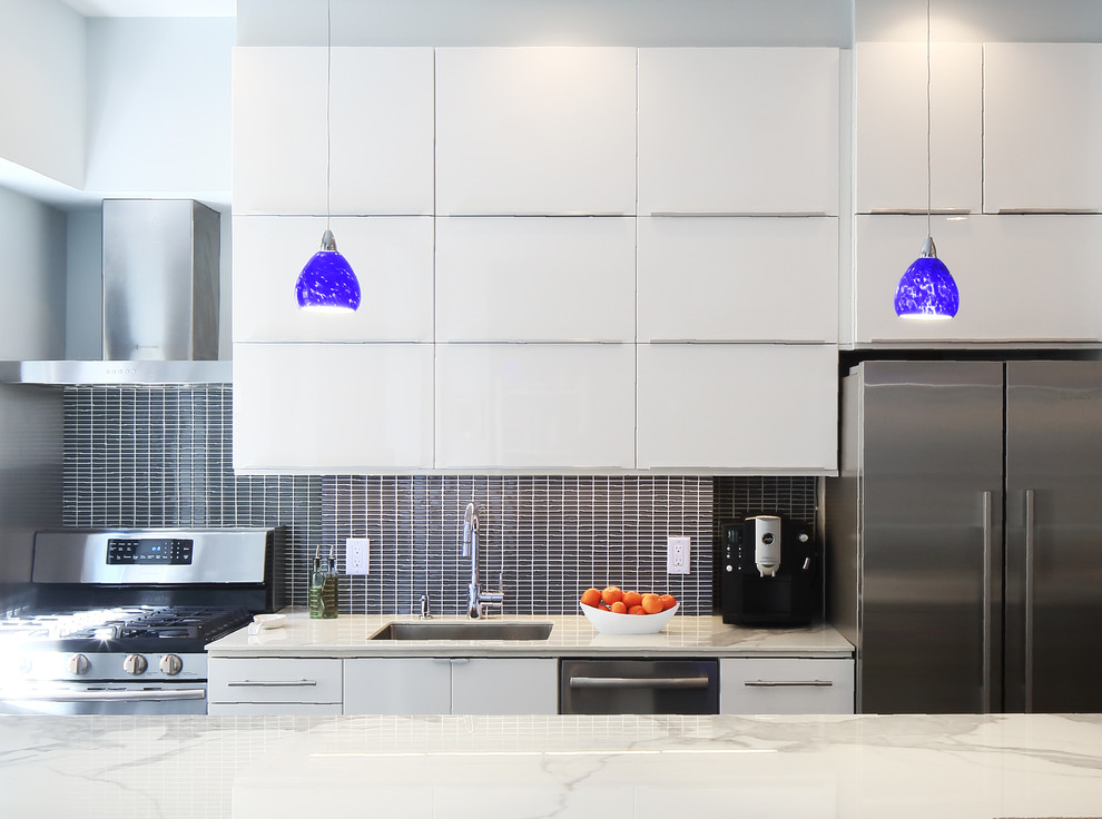 Inspiration for a small contemporary galley open plan kitchen in New York with an undermount sink, flat-panel cabinets, white cabinets, blue splashback, glass tile splashback, stainless steel appliances, linoleum floors and a peninsula.
