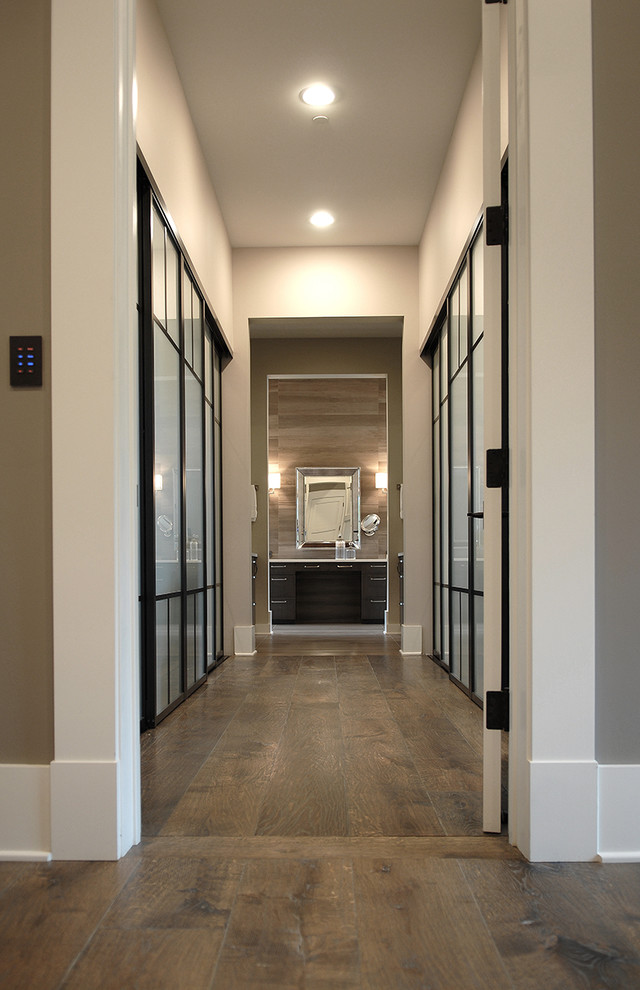 Inspiration for a large industrial medium tone wood floor and brown floor hallway remodel in Chicago with white walls