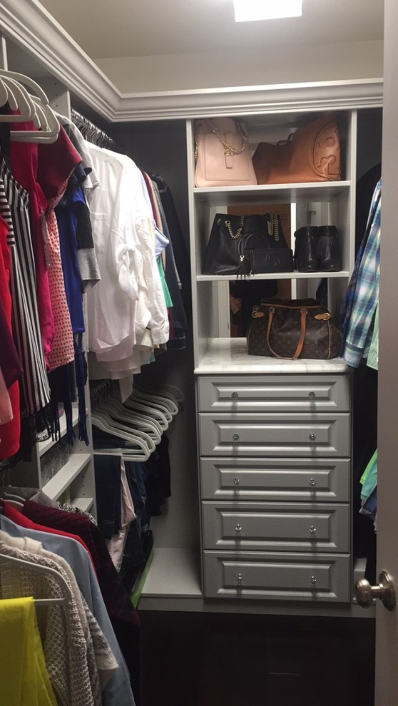 Foto de armario vestidor contemporáneo de tamaño medio con armarios con paneles con relieve, puertas de armario grises y suelo de madera oscura
